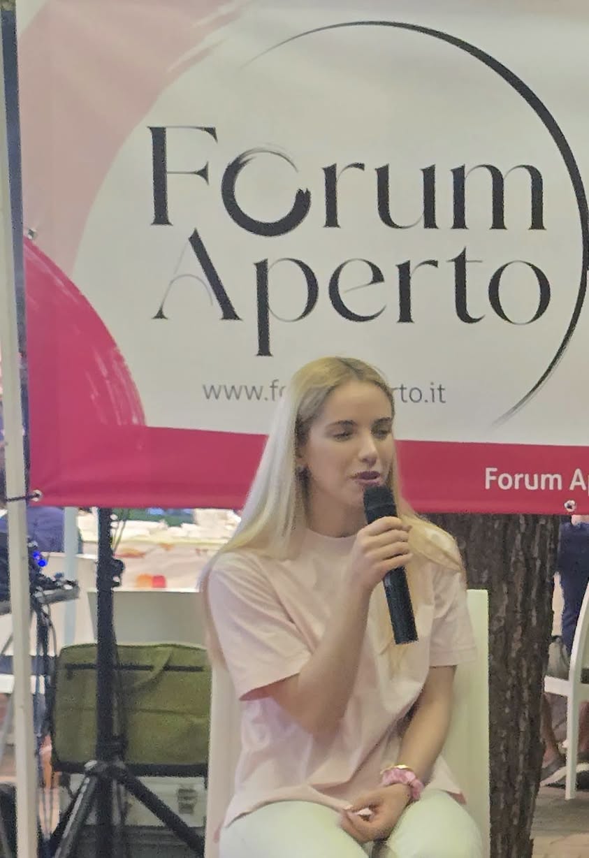 Roberta Lacatena al microfono sul palco di Forum Aperto